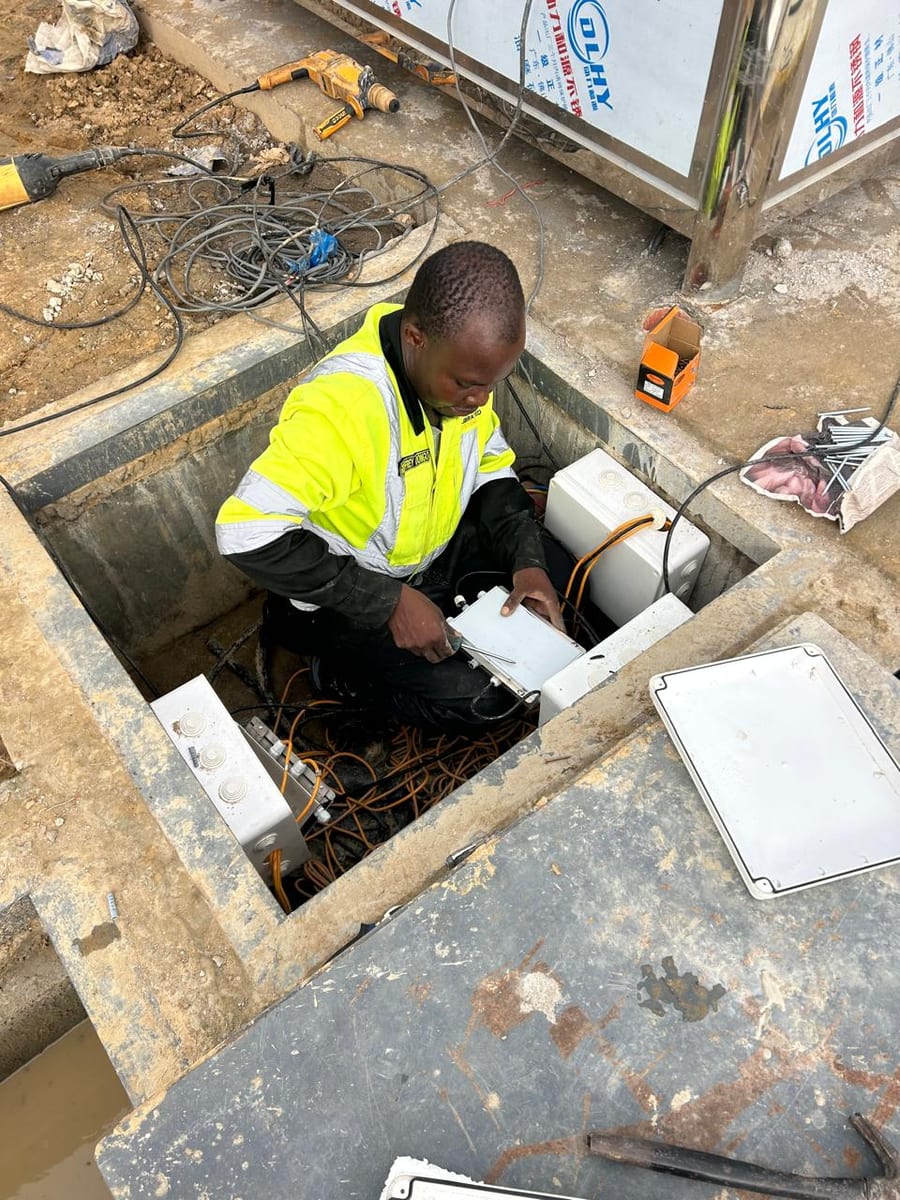 Engineer in a weighbridge pit in Kenya wiring load cell cables into the junction boxes during installation